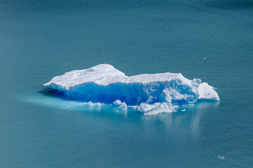 'Blue iceberg floating in the Hornsund Spitzbergen. Blue ice is very old ice, which was under pressure by the glacier. The cloudy, fogy weather is typical for the north and the light show the wide spectrum of the blue colors.'