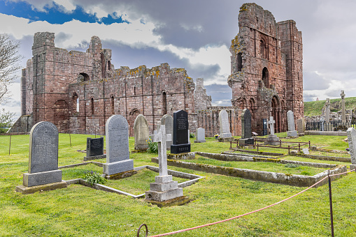 Lindisfarne, Holy Island, Berwick-upon-Tweed, Northumberland, England, Great Briton, United Kingdom. May 1, 2022. Graveyard at the ruins of the Lindisfarne Priory.