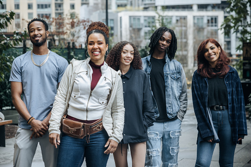 A group of African American friends look at the camera for a fun portrait.  Youth culture, style, fashion, and identity. Shot in Seattle, Washington, USA.