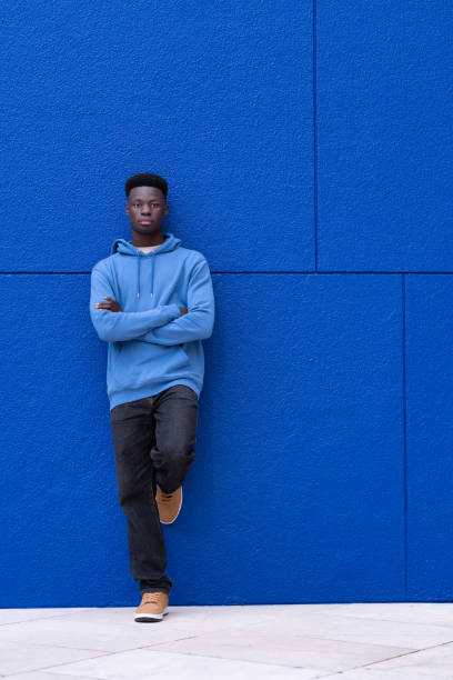 istock Attractive young black man leaning on a wall wearing blue sweatshirt, on a blue background, with copy space. Relaxation concept. 2063898850