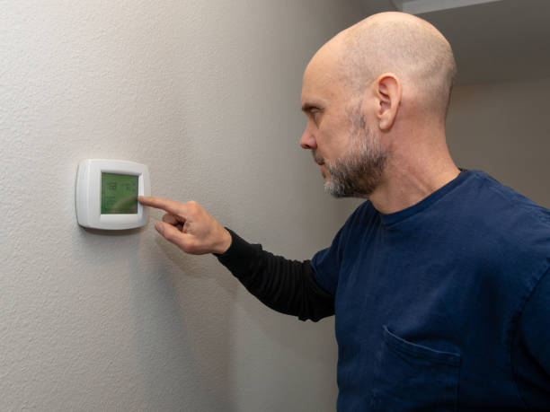 istock Home Inspector Examining Thermostat 2063907327