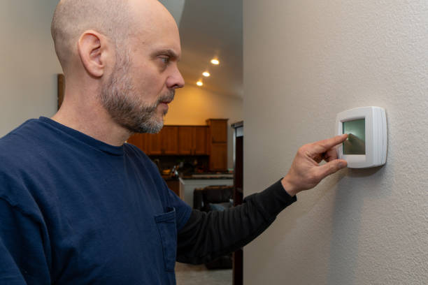 istock Home Inspector Examining Thermostat 2063907328