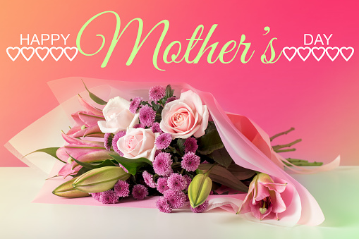 Mothers day card. Bouquet of pink roses in basket and greeting text on wooden background closeup