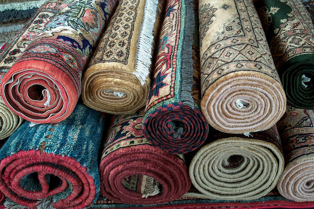 istock Rugs, different Persian style stacked roll rugs, many rolls of assorted rugs 2063948127