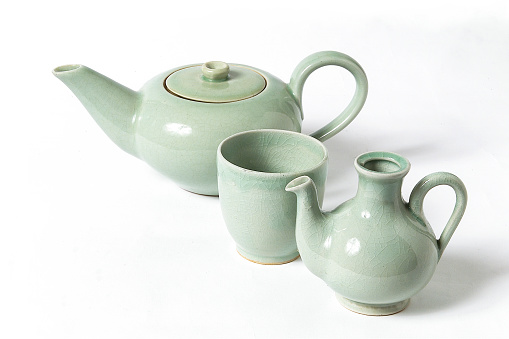 Japanese ceramics, traditional Japanese green teapot and cups on white background with space for your text or design