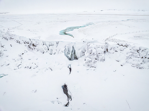 Aerial view of Oxarafoss, or the waterfall in the Ax River, in the Thingvellir national park in winter, Iceland