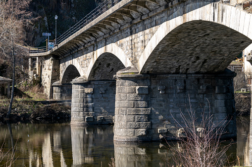 Bridge of the medieval village of Puebla de Sanabria reflected in the river Tera, Zamora, Castilla y León, Spain.