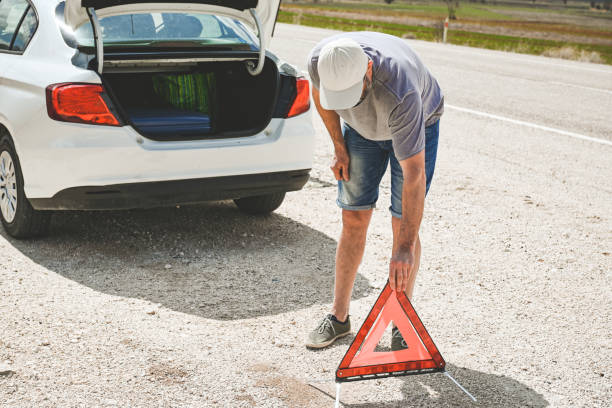 man stands by a broken car - stranded travel people traveling disappointment - fotografias e filmes do acervo