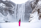 Tourist on the Skogafoss waterfall background. Travelling on Iceland. Tourist woman in the famouns place in Iceland. Travel image