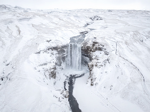 Aerial drone view of Skogafoss Waterfall in Iceland a Beautiful Landmark Covered in Snow in winter