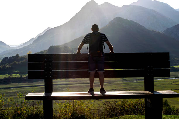 istock A man perched on a large-scale bench contemplates the beautiful scenery. 2064021946