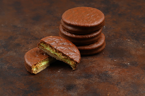 Delicious choco pies on wooden table, closeup. Space for text