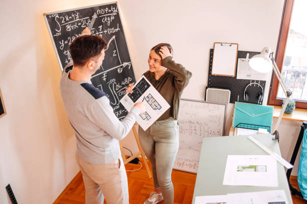 istock Architecture students working together on project standing in front of black board 2064041768