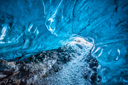 Entrance of an crystal blue ice cave with underground path inside Vatnajokull glacier, Iceland