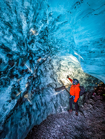 Tourist discovering the ice cave in Falljokull Glacier (Falling Glacier) part of the Vatnajokull glacier in Iceland