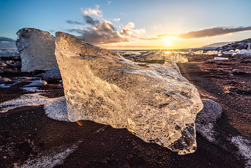 View of ice blocks at sunset on the famous Diamond Beach with black lava sand, South Iceland