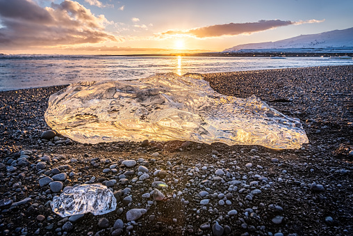 different size Ice rocks on a black sand beach known as Diamond beach at Jokulsarlon glacier in Iceland at twilight