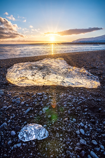 View of ice blocks at sunset on the famous Diamond Beach with black lava sand, South Iceland