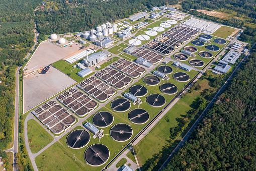A new, large water sewage treatment plant surrounded by forests seen from above.
