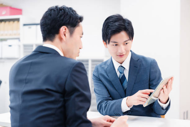 istock Businessman using a tablet terminal to explain at the counter. 2064133985