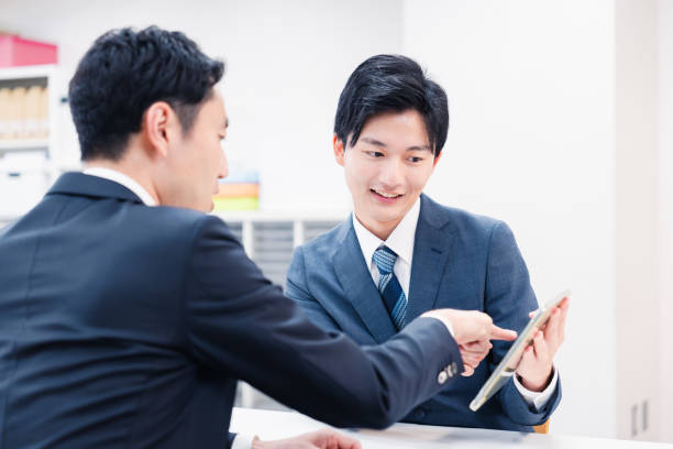 istock Businessman using a tablet terminal to explain at the counter. 2064133990
