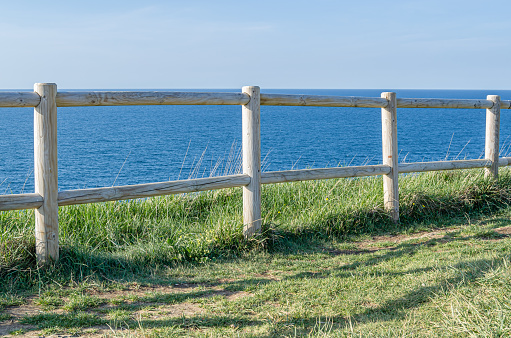 Path and wooden fence on the coastline of the Cantabrian Sea in Santander, northern Spain