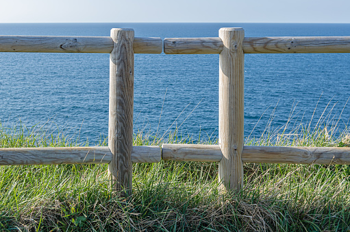 Path and wooden fence on the coastline of the Cantabrian Sea in Santander, northern Spain