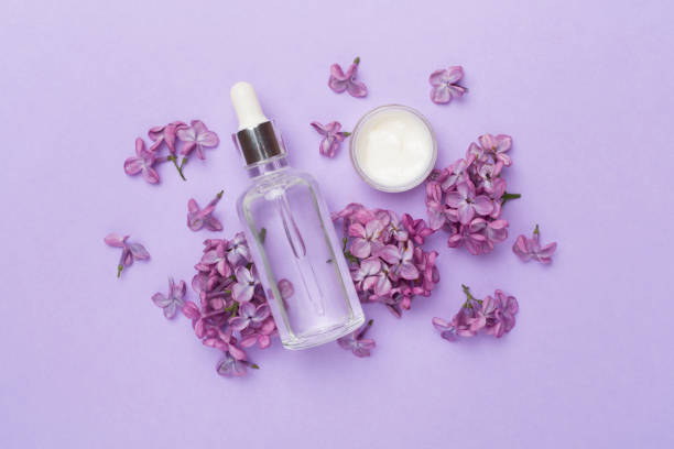 istock Composition with cosmetic bottle and flowers on color background, top view 2064261546