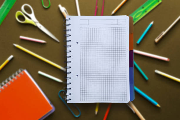 istock Open notebook with copy space for text on blurred dark background with variety of school supplies. 2064262062
