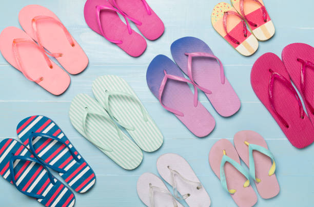 istock Many bright flip flops on wooden background, top view 2064265662