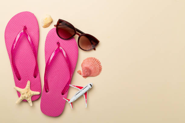 istock Flip flops with sunglasses and airplane on color background, top view 2064265663