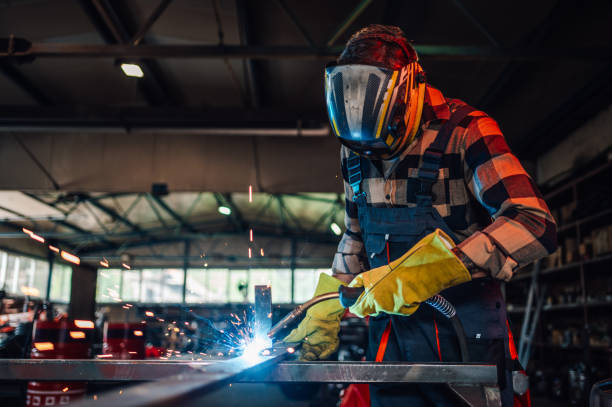 istock Young man welding a piece of metal while making a metal construction. 2064286774