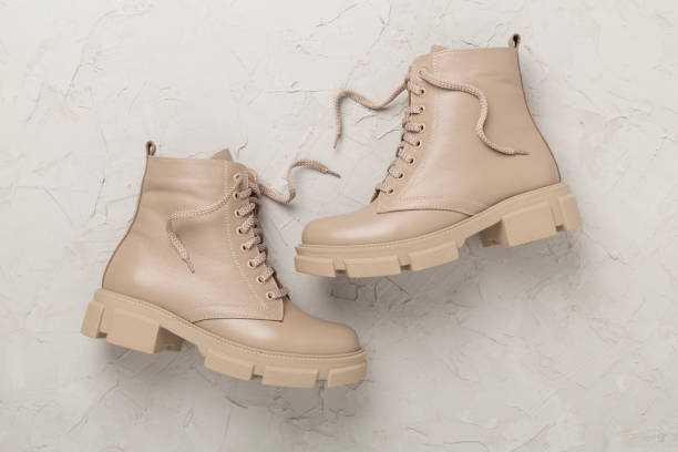 istock Beige trendy boots on concrete background, top view. 2064295612