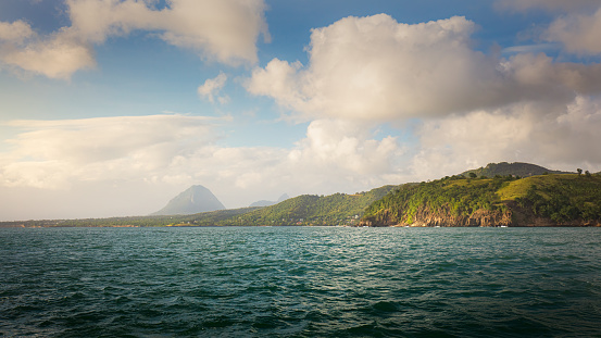 Late afternoon view of St Lucia coast from the ocean. Pitons can be seen through the haze.