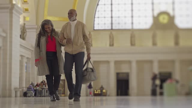 African American couple on romantic getaway dancing in train station