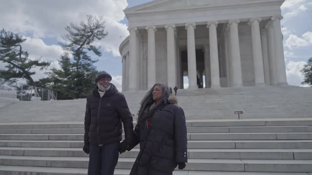 Senior couple walking down steps in front of the Jefferson Memorial