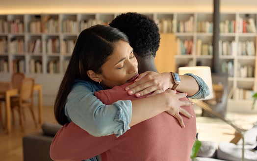 Couple, university and embrace for care and bonding, support and love in relationship on college. Interracial people, trust and hug for security or connection, library and romance on campus for date