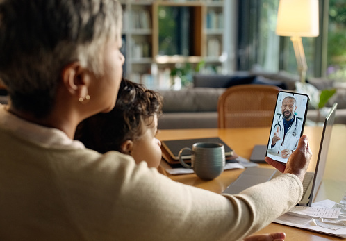 Video call, doctor and family with phone for medical service, consulting or telehealth in home. Healthcare, medicine and mother and child on smartphone for conversation, discussion and communication