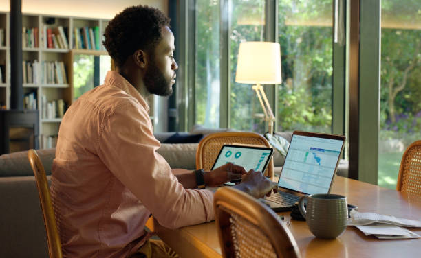 istock Laptop, home and business black man with statistics, graph and chart analysis for online report. Remote work, consultant and person on computer, tablet and technology for project, review and research 2064375698