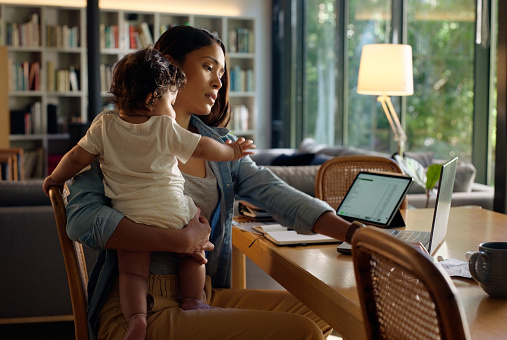 Woman, baby and laptop in home for remote work with project research, corporate planning and reading information. Entrepreneur, mother and child with technology at table in living room for online job