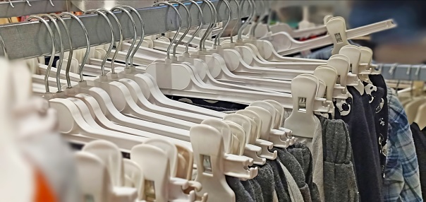 different clothes hanging on a white hanger in a supermarket