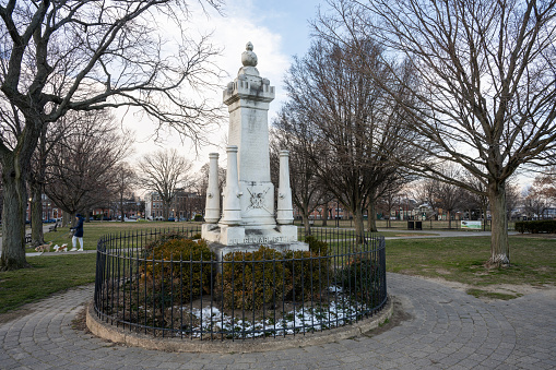 Baltimore, USA - February 18, 2024. Monument to George Armistead with a lady walking dogs on left at Federal Hill Park, Baltimore, Maryland, USA