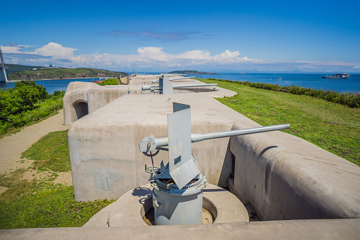 Gun of coastal batterie in Vladivostok fortress and Cable-stayed bridge. Island of Russian, Vladivostok, Russia.