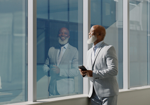 Window, smile and CEO with smartphone in office building for morning planning, vision and daily inspiration. Workplace, idea and businessman with technology for networking, communication or break