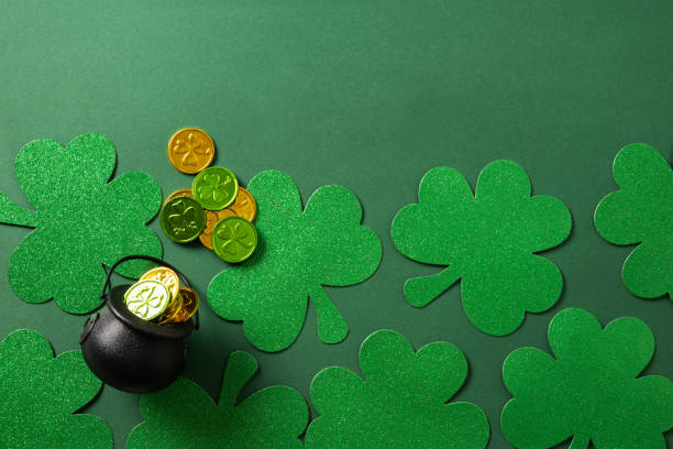 istock St. Patrick's day black pot with coins on green background. 2064429504