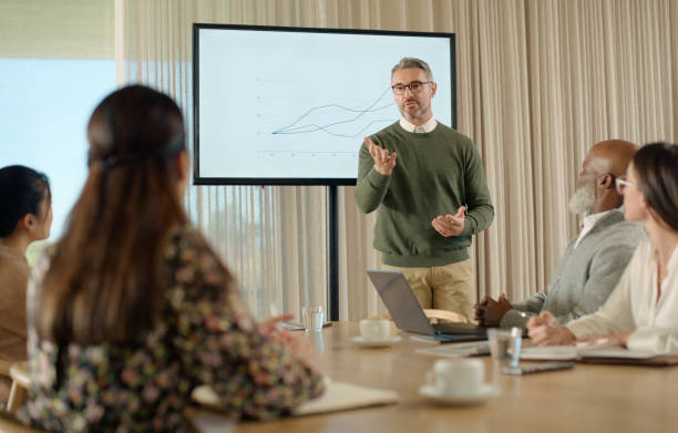 istock Meeting, presentation or business people in office with chart, graphs or financial budget discussion. Finance, training or mature man speaker with digital display board for data analytics or feedback 2064470618