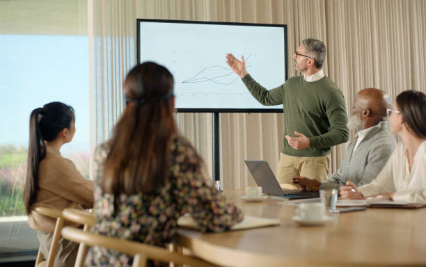 istock Presentation, monitor and business man with data analytics, statistics and speaking of financial growth in meeting. Senior analyst, CEO or boss in workshop with graphs, charts and increase on screen 2064470623