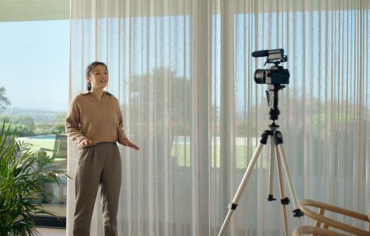 Woman, recording and camera in office for broadcast with business advice, knowledge and workshop. Person, speaker and presenter with talking, tripod and microphone with video, podcast and streaming