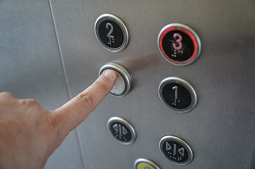 Finger pressing an elevator button. Concept: mechanical engineering