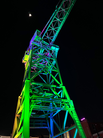 Baltimore, USA - February 17, 2024. Crane illuminated by color lights at night, Baltimore, Maryland, USA